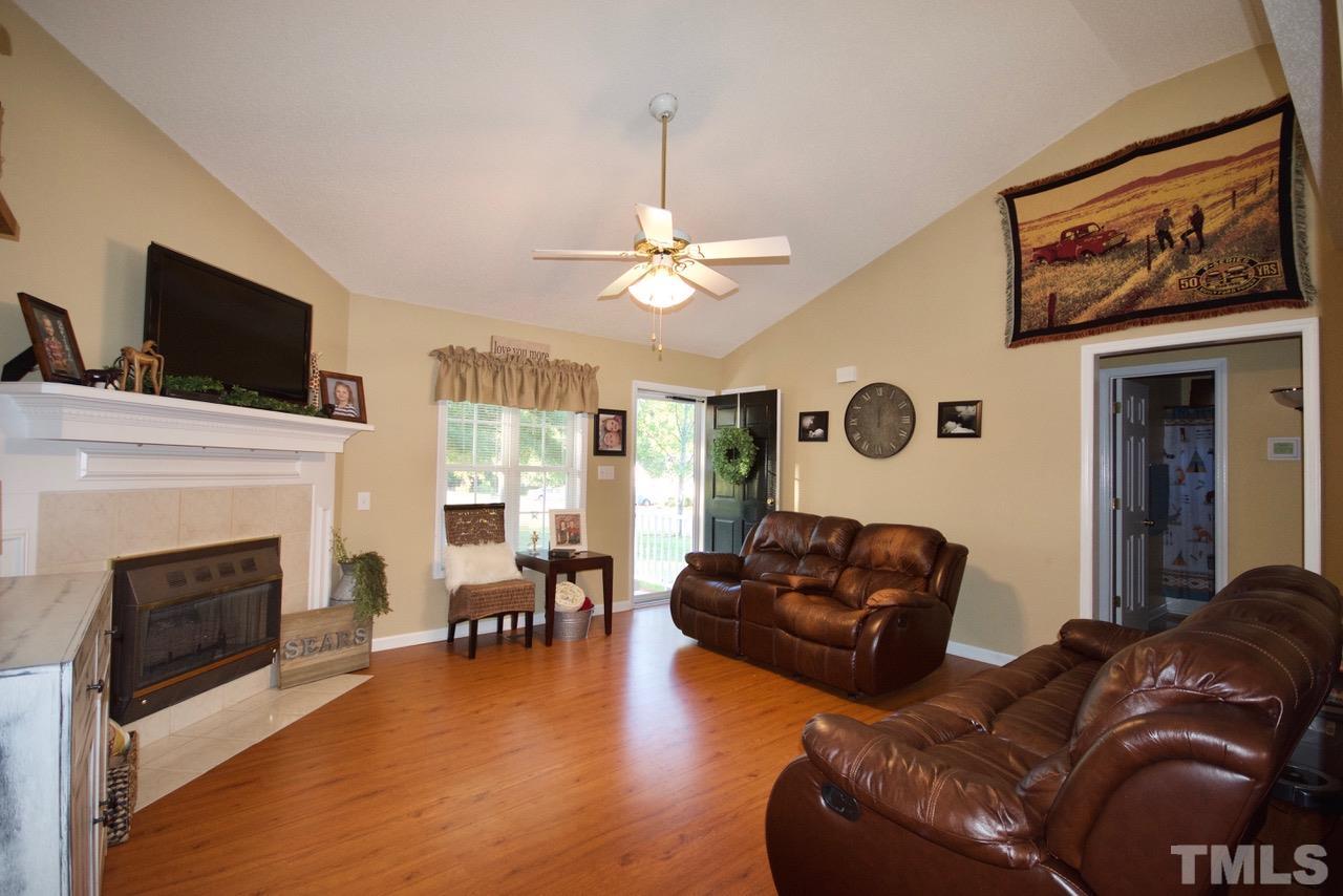 128 Forest Ridge Drive Willow Spring, NC 27592 - Photo 5 of 25 a living room with furniture a fireplace and a flat screen tv