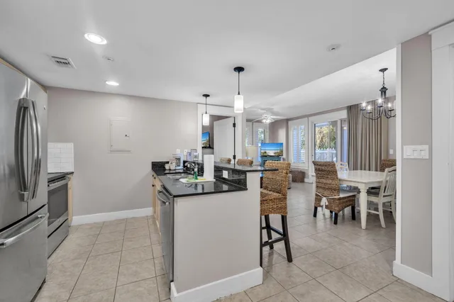 a kitchen with stainless steel appliances kitchen island granite countertop a refrigerator and a stove top oven