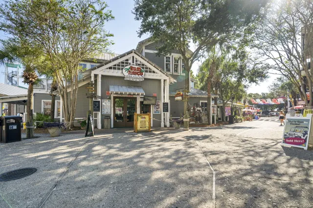 a view of a white house with a large tree in front of it