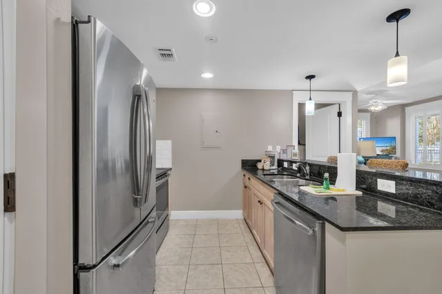 a large kitchen with granite countertop a refrigerator and a sink
