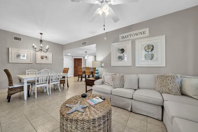 a living room with furniture a dining table and a chandelier