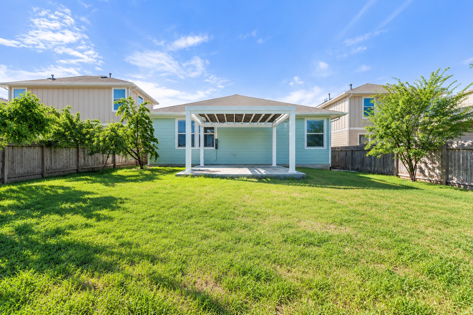 121 Guemal Road Buda, TX 78610 - Photo 13 of 13 An inviting backyard features a spacious grassy lawn and a patio with a white pergola.