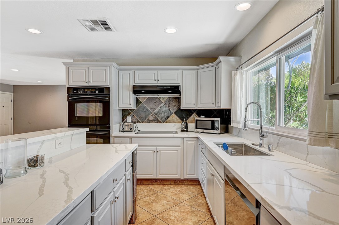 4153 Woodcrest Road Las Vegas, NV 89121 - Photo 14 of 58 Culinary delights await in this bright kitchen, complete with generous counter space and abundant storage.