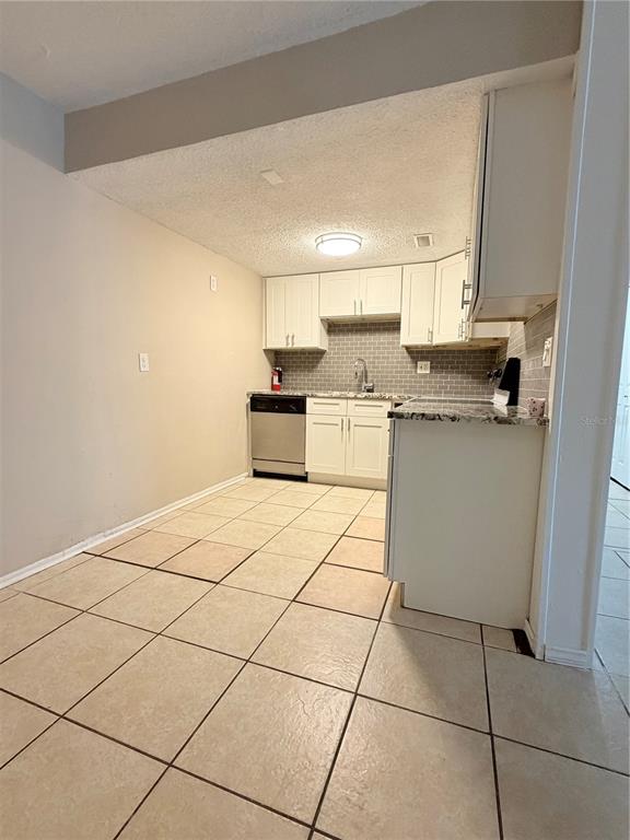908 Lake Destiny Road, Unit B Altamonte Springs, FL 32714 - Photo 4 of 16 a kitchen with a sink a stove top oven and white cabinets