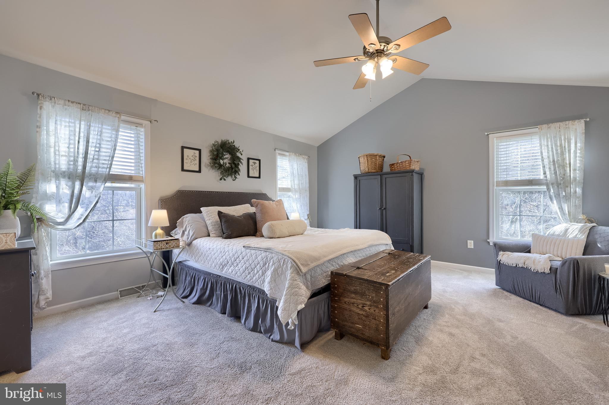 471 Shenks Ferry Road Conestoga, PA 17516 - Photo 46 of 105 a spacious bedroom with a bed a couch and a chandelier fan