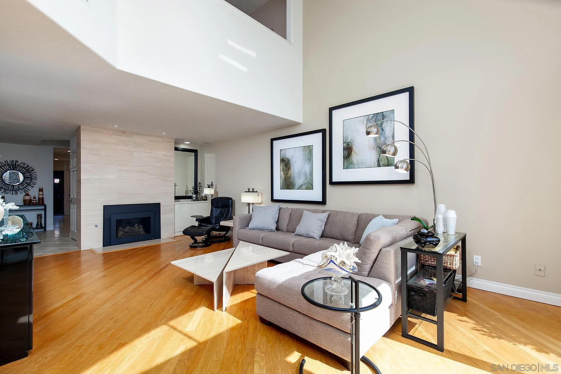 5 Aruba Bend Coronado, CA 92118 - Photo 9 of 40 a living room with furniture a fireplace and a dining table with wooden floor