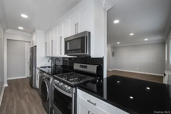 a kitchen with stainless steel appliances granite countertop a stove a refrigerator and a microwave