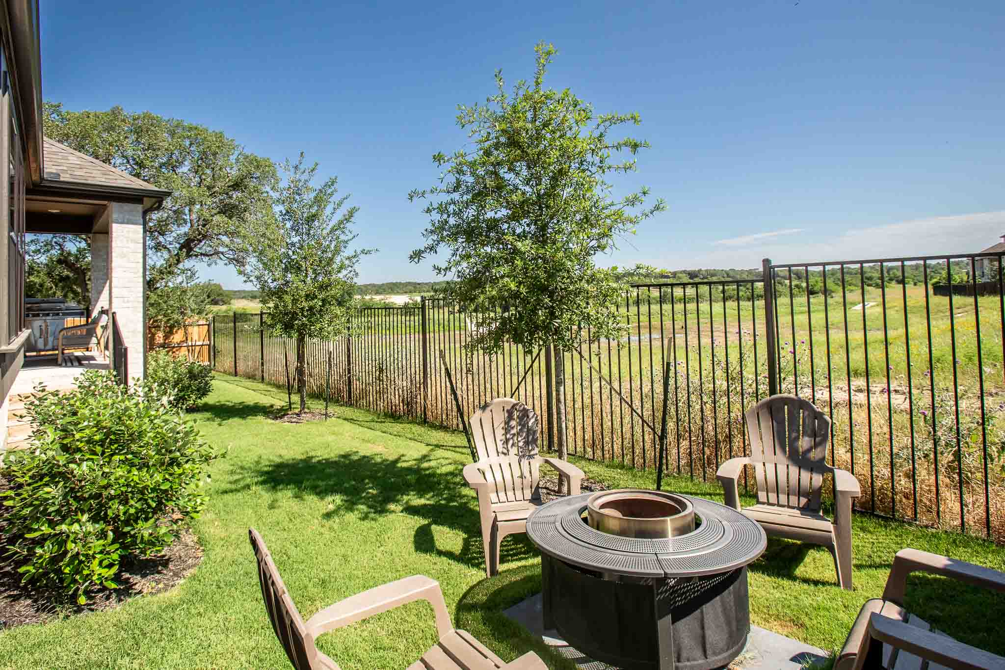 220 Basket Flower Loop Kyle, TX 78640 - Photo 37 of 40 A tranquil backyard offers a fire pit, ready for memorable evenings under the open sky.
