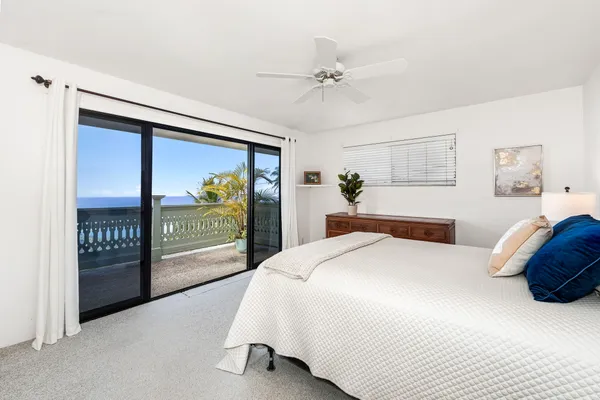 a bedroom with a balcony a bed and a painting on the wall
