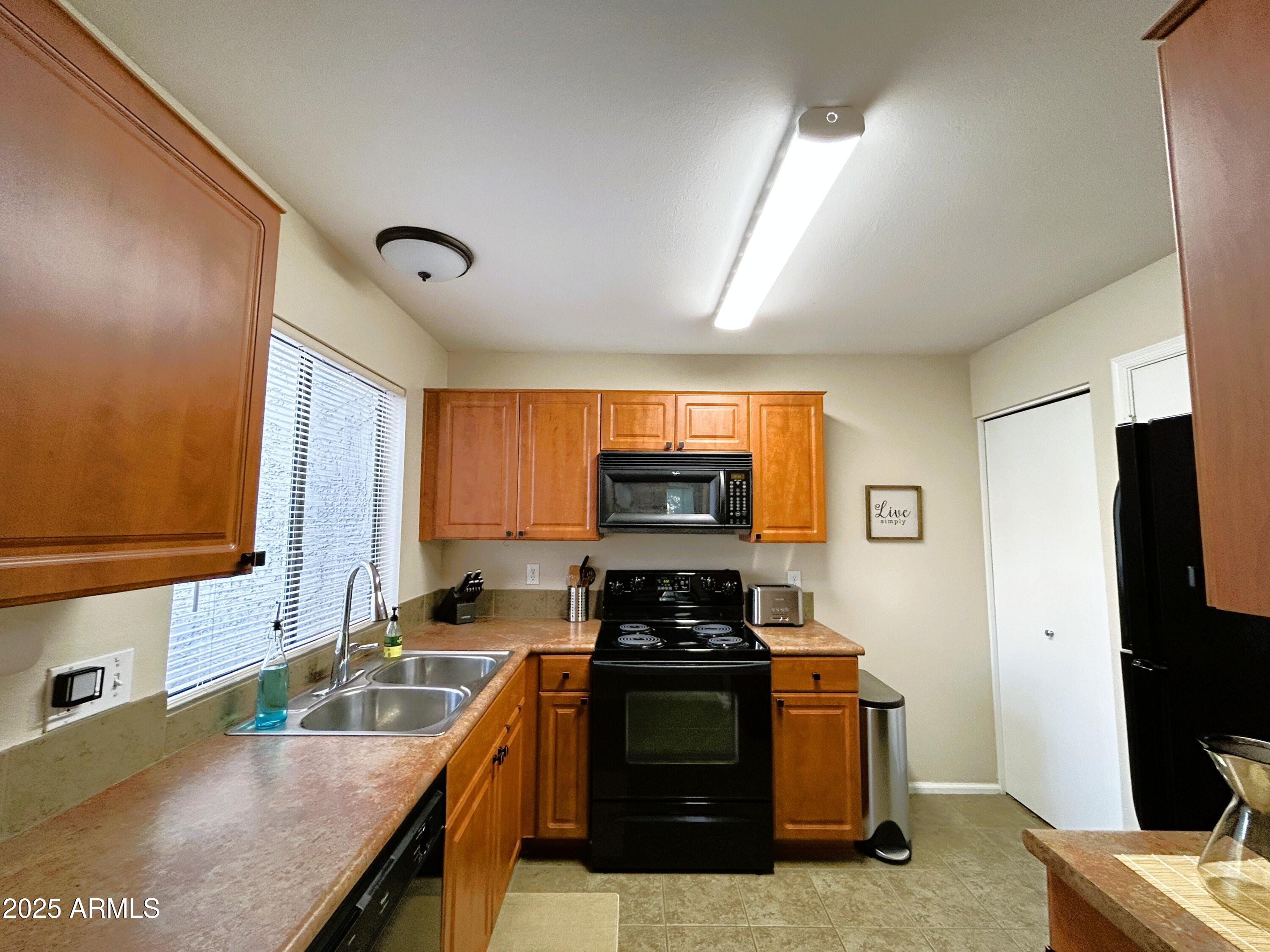 10055 East Mountainview Lake Drive, Unit 2059 Scottsdale, AZ 85258 - Photo 12 of 34 a kitchen with stainless steel appliances granite countertop a stove a sink and a microwave