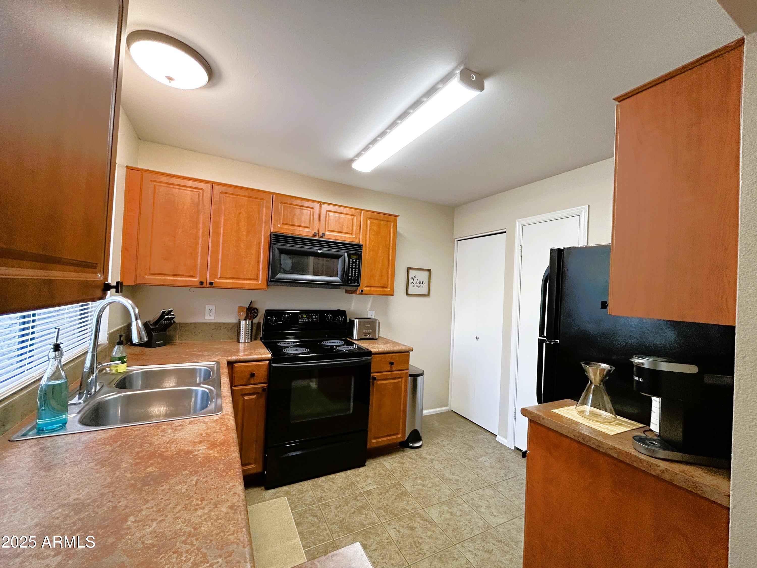 10055 East Mountainview Lake Drive, Unit 2059 Scottsdale, AZ 85258 - Photo 13 of 34 a kitchen with stainless steel appliances granite countertop a stove top oven a sink dishwasher and a refrigerator
