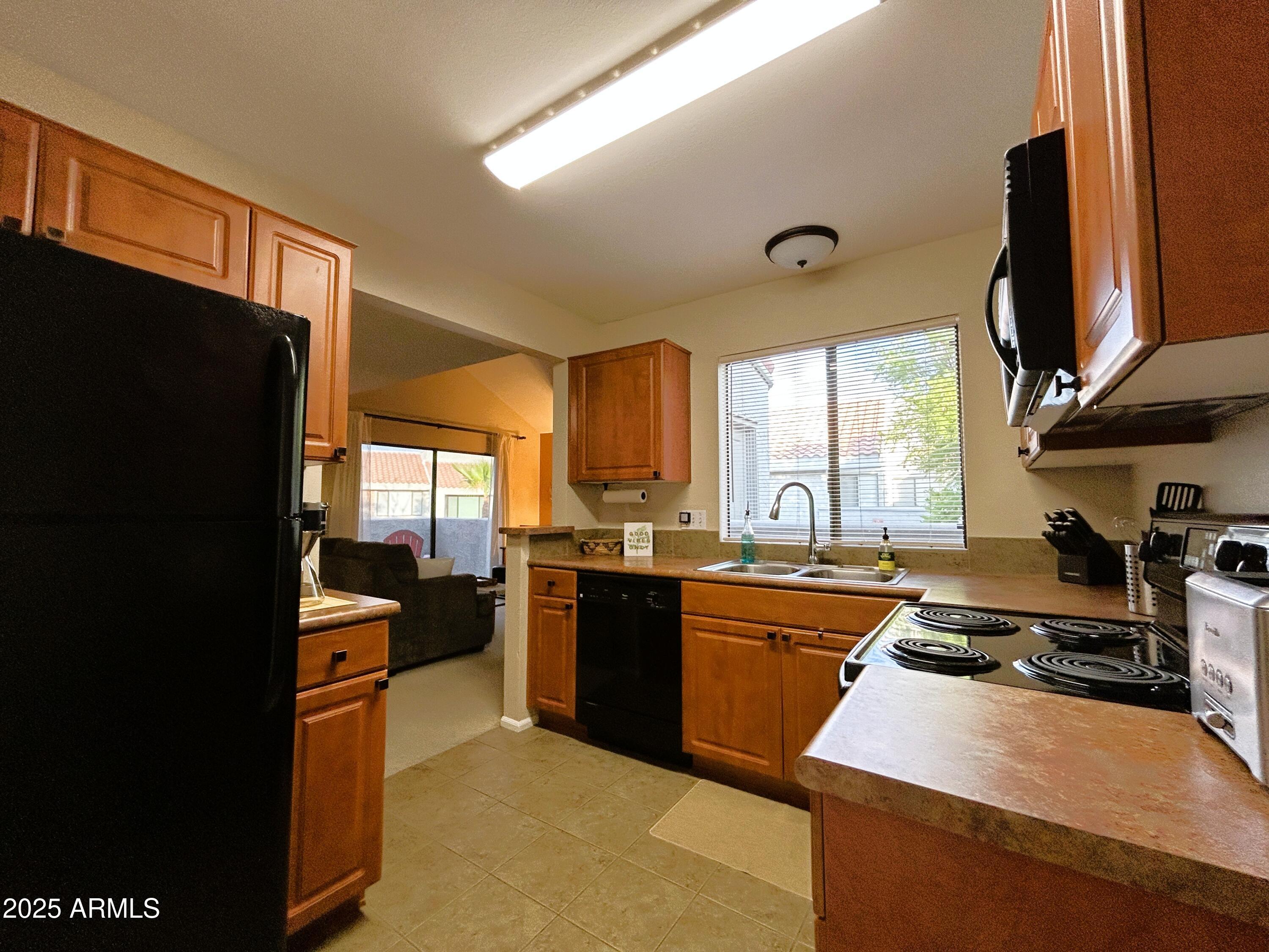 10055 East Mountainview Lake Drive, Unit 2059 Scottsdale, AZ 85258 - Photo 14 of 34 a kitchen with stainless steel appliances granite countertop a sink stove and refrigerator