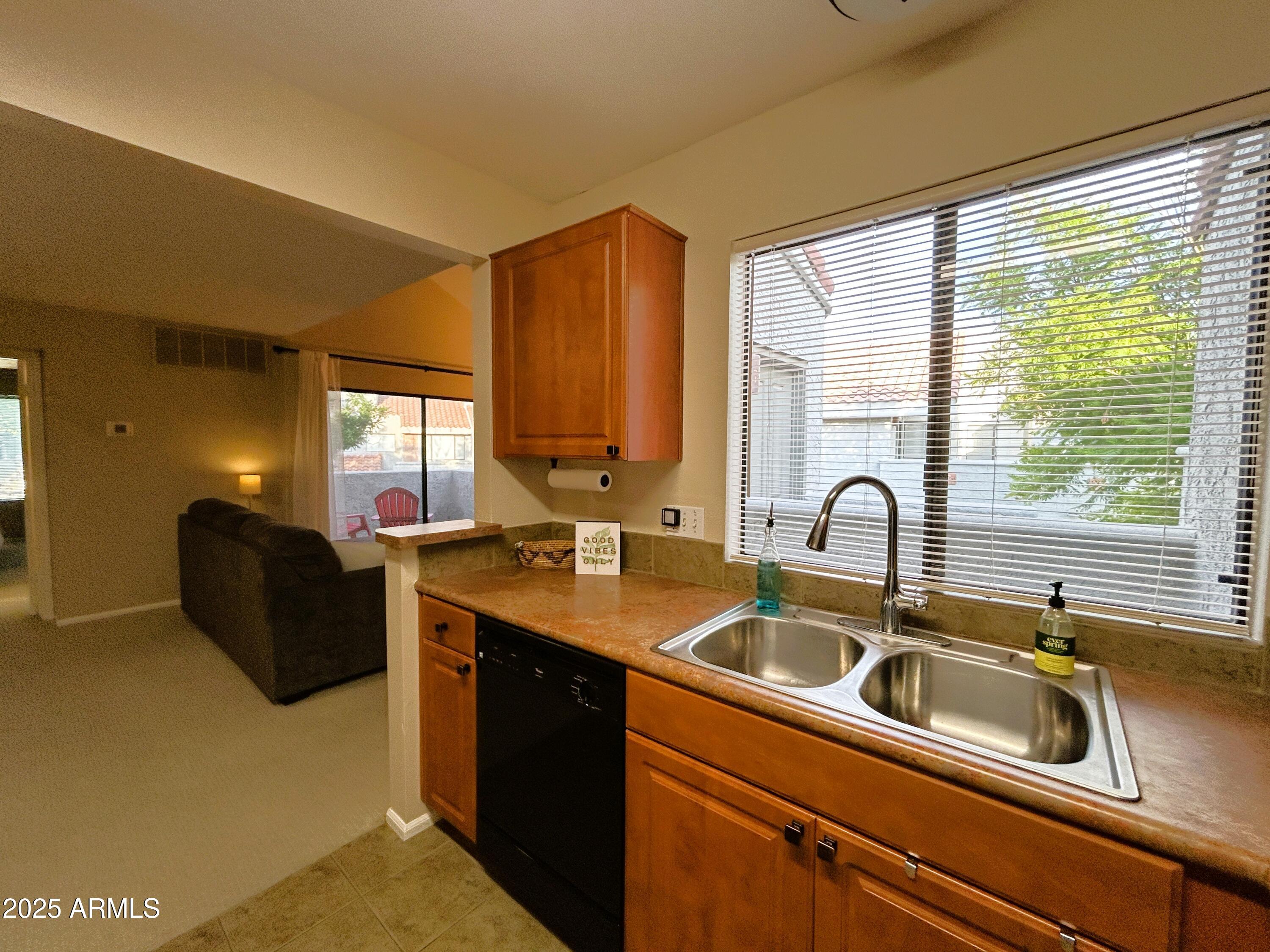 10055 East Mountainview Lake Drive, Unit 2059 Scottsdale, AZ 85258 - Photo 18 of 34 a kitchen with stainless steel appliances granite countertop a sink a stove and a refrigerator with wooden floor