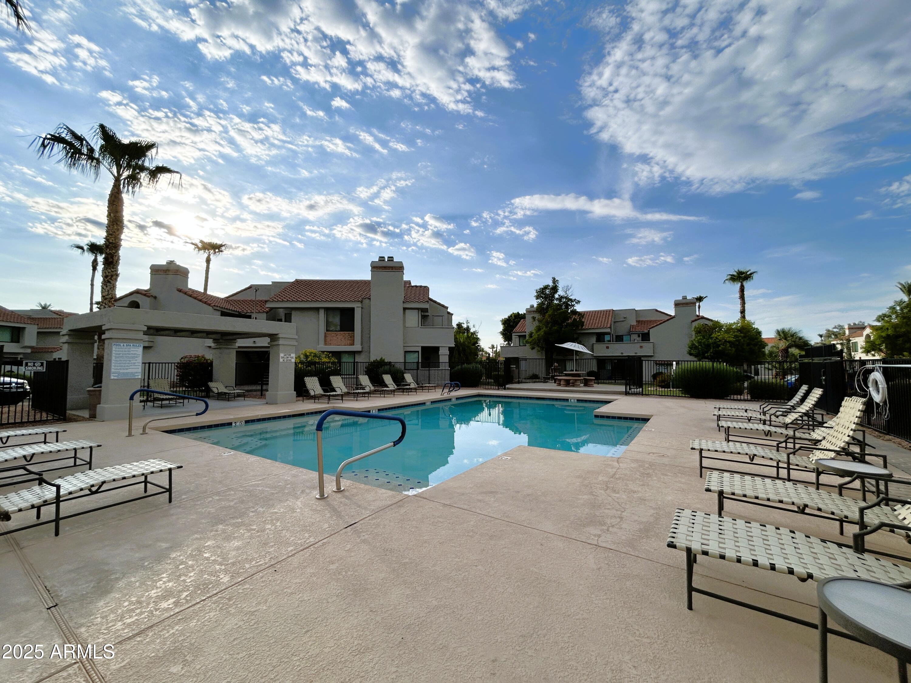 10055 East Mountainview Lake Drive, Unit 2059 Scottsdale, AZ 85258 - Photo 5 of 34 a view of a swimming pool with lounge chairs