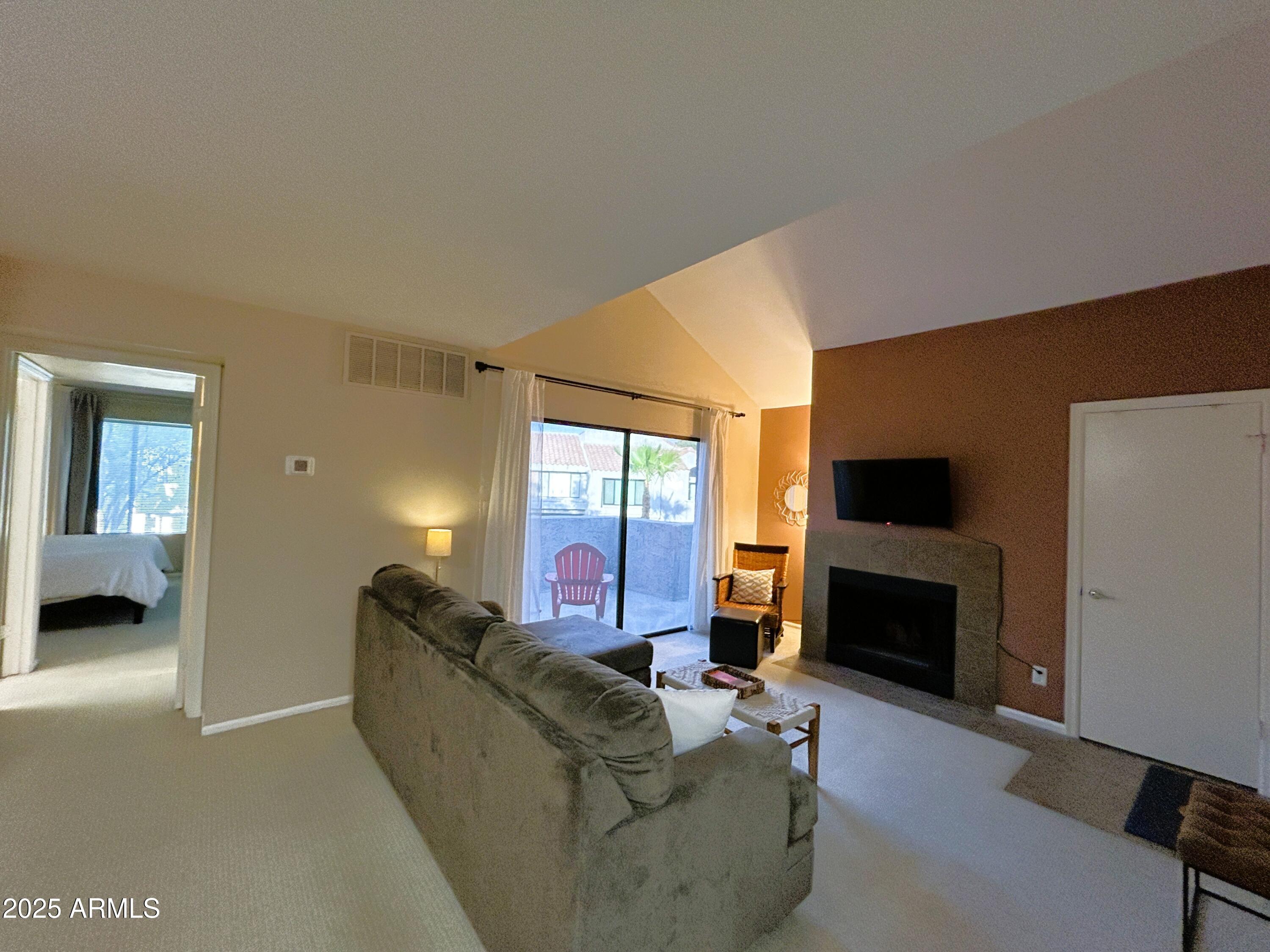 10055 East Mountainview Lake Drive, Unit 2059 Scottsdale, AZ 85258 - Photo 9 of 34 a living room with furniture a flat screen tv and a fireplace