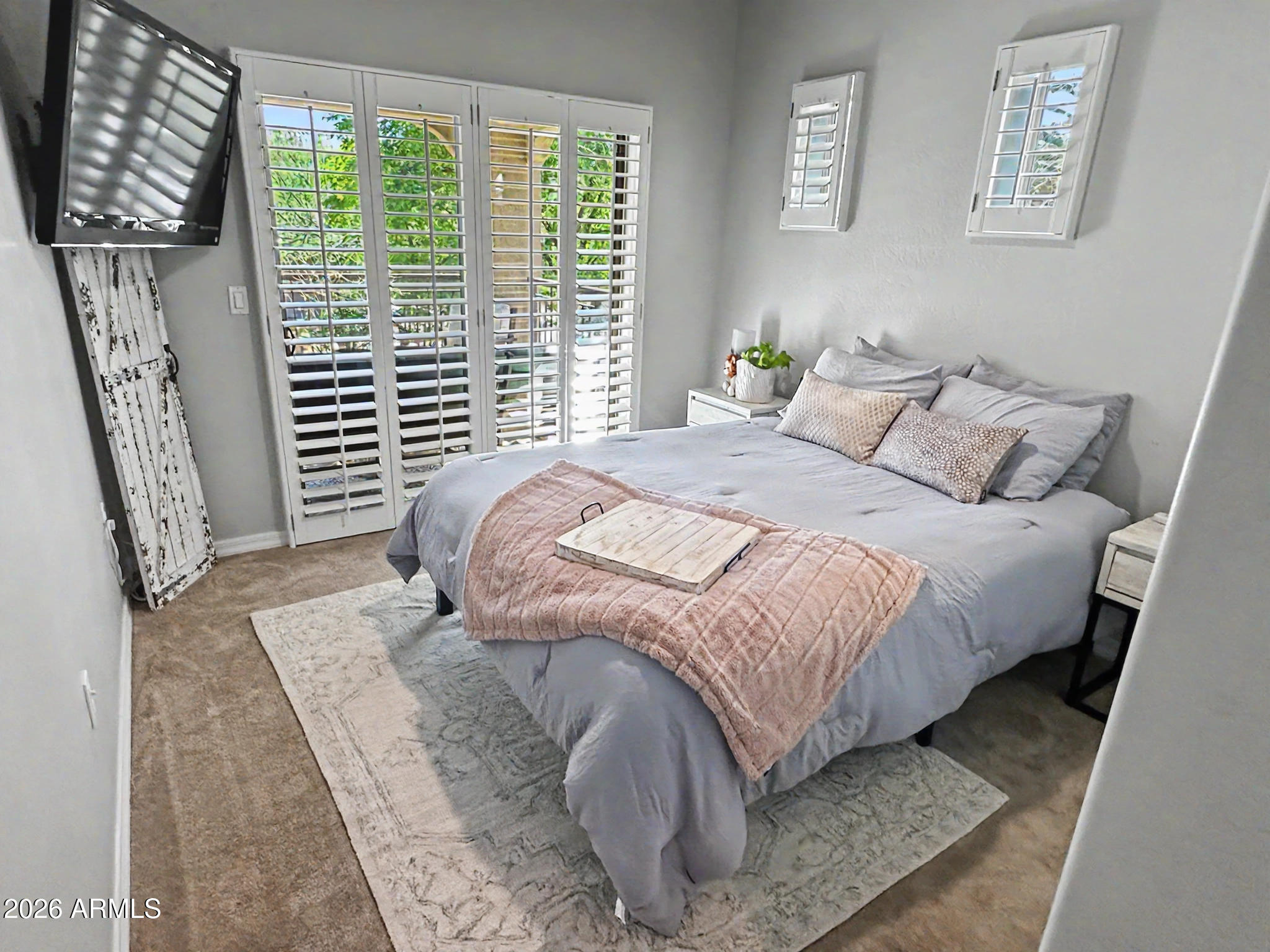 3935 East Rough Rider Road, Unit 1144 Phoenix, AZ 85050 - Photo 15 of 31 a bed sitting in a bedroom next to a window