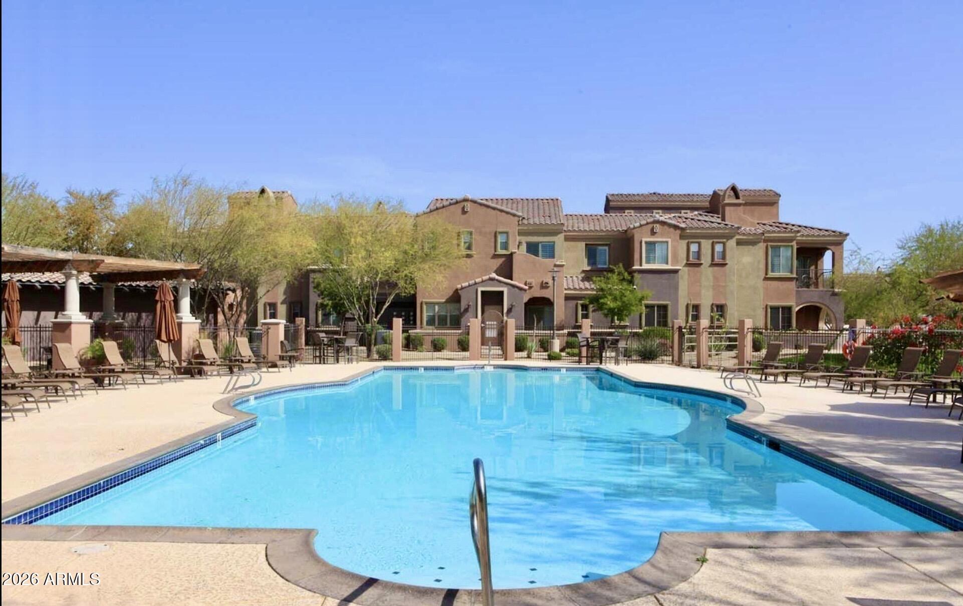 3935 East Rough Rider Road, Unit 1144 Phoenix, AZ 85050 - Photo 23 of 31 a view of a swimming pool with outdoor seating
