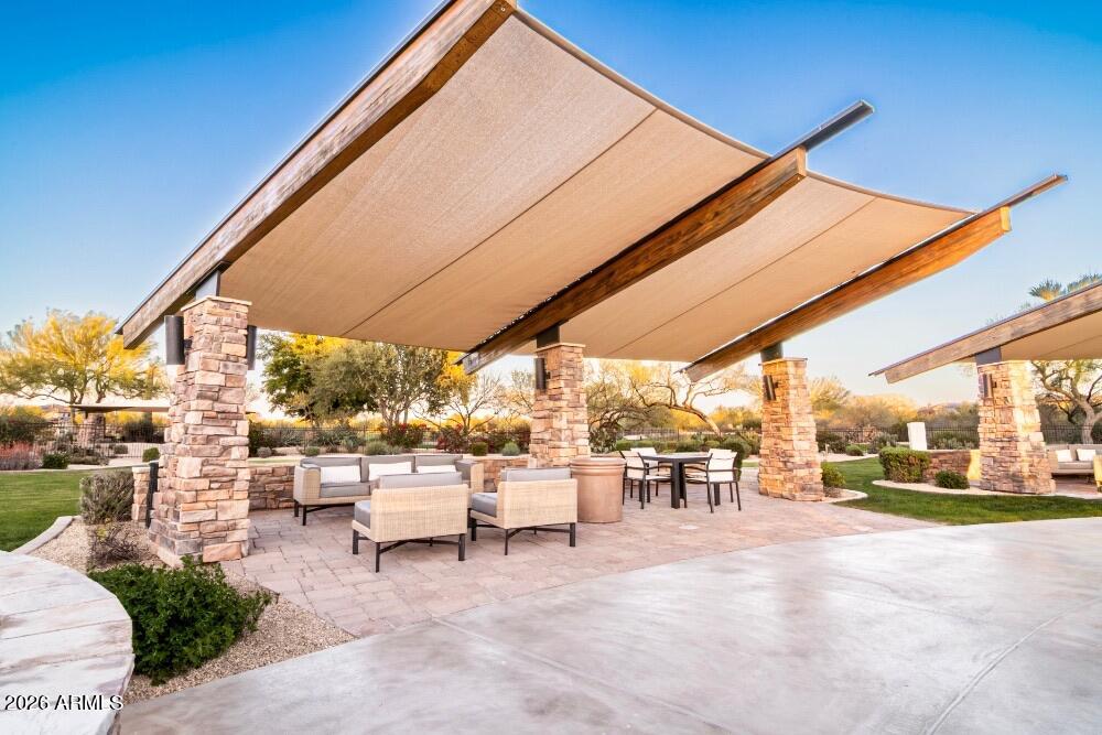 3935 East Rough Rider Road, Unit 1144 Phoenix, AZ 85050 - Photo 27 of 31 a view of a patio with a table and chairs under an umbrella
