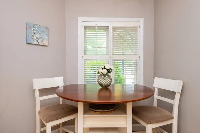 a dining room with furniture a large window and a chandelier