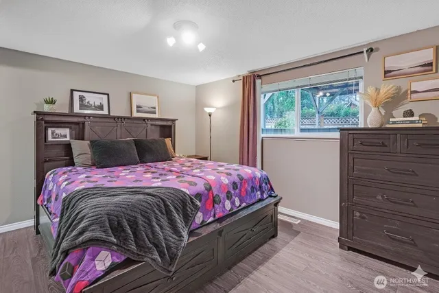 a bedroom with a bed and wooden floor