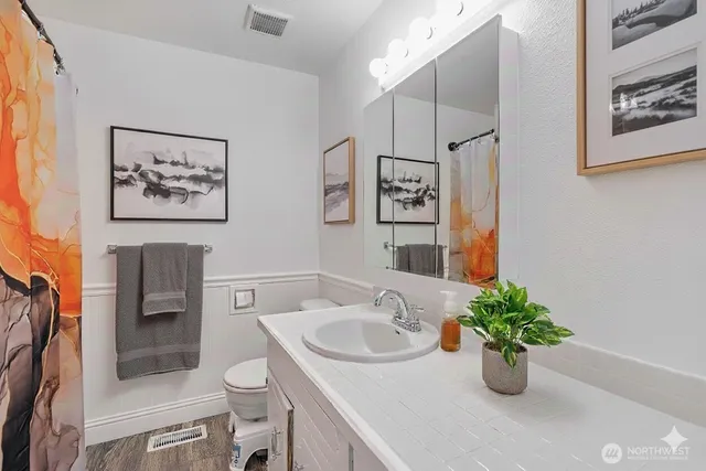 a bathroom with a sink a toilet and a mirror