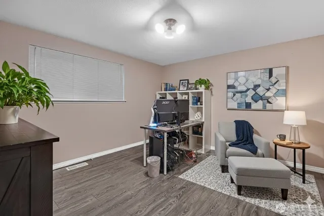 a view of a workspace with furniture and wooden floor