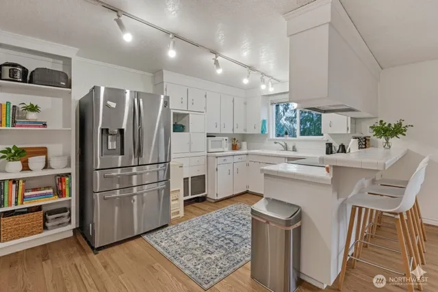 a kitchen with stainless steel appliances a refrigerator sink and cabinets