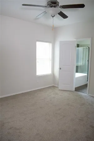 an empty room with a window and a ceiling fan