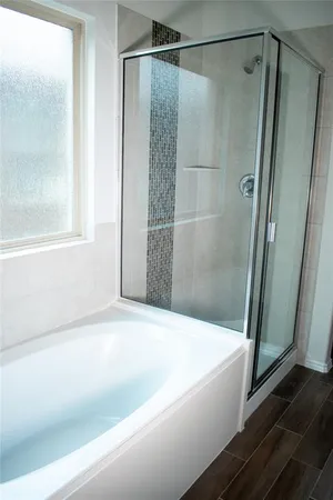 a bathroom with a shower and a bath tub