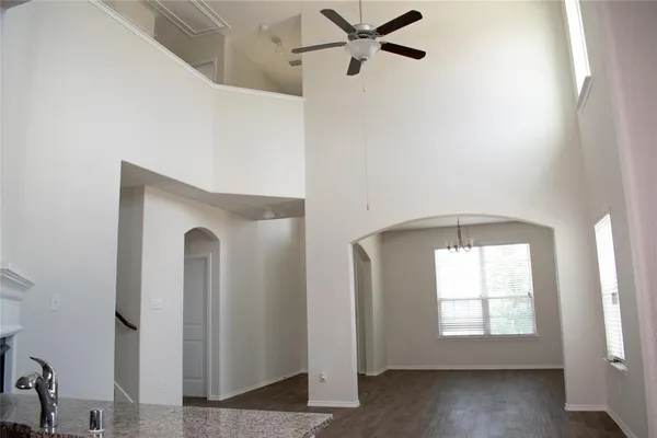 a view of a hallway with windows and chandelier fan
