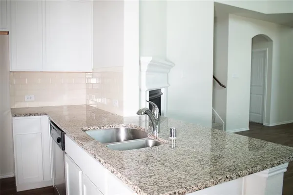 a kitchen with a sink a counter top space and cabinets