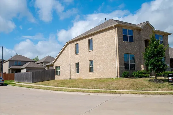 a view of a big house with a big yard and large trees