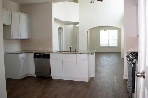a view of a kitchen with wooden floor and electronic appliances