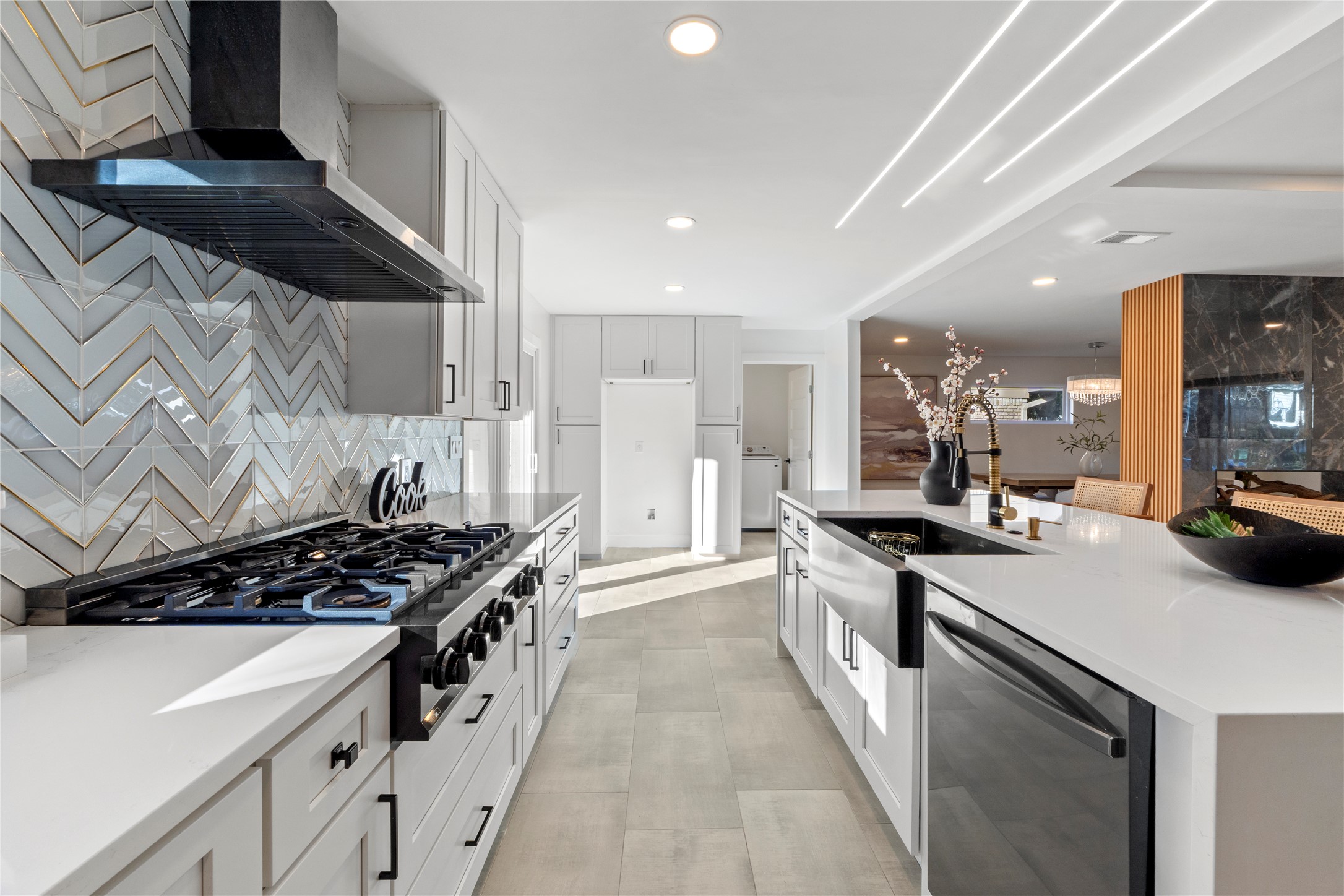 6604 Lexington Road Austin, TX 78757 - Photo 9 of 33 Kitchen with wall chimney exhaust hood, stainless steel dishwasher, light stone counters, black gas cooktop, and white cabinetry