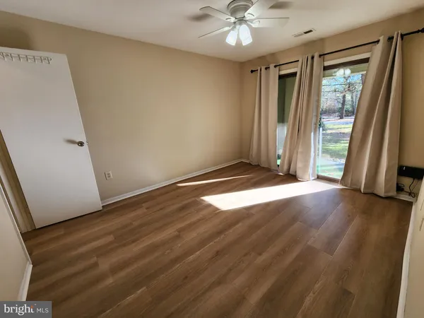 an empty room with wooden floor and sliding door