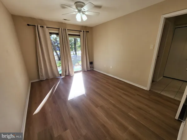 an empty room with wooden floor and windows