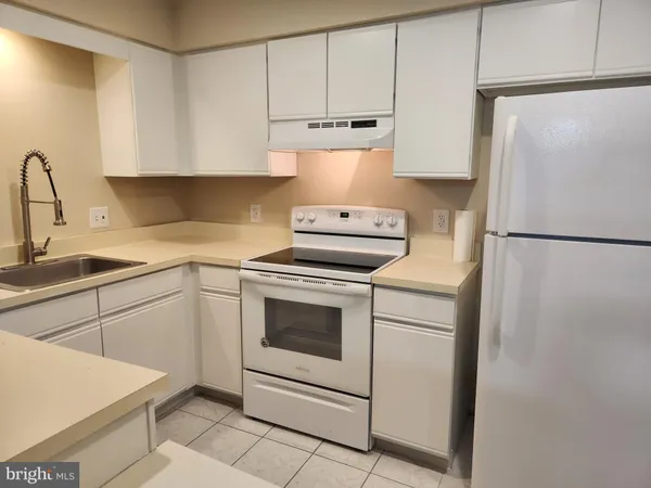 a kitchen with a refrigerator sink stove and cabinets