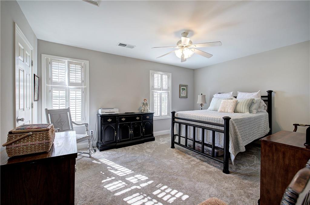 618 Manor Way Cartersville, GA 30120 - Photo 21 of 35 a spacious bedroom with a bed and a chandelier