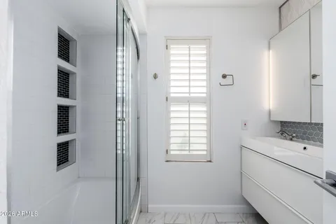 a bathroom with a sink a toilet and shower