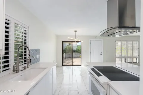 a bathroom with a granite countertop sink a bathtub and next to a window