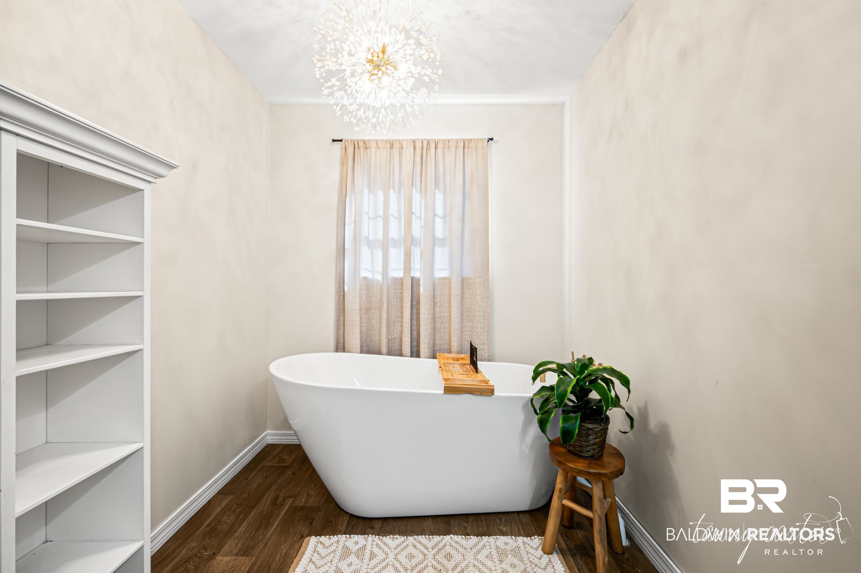 3086 Wild Fork Road Frisco City, AL 36445 - Photo 21 of 30 Full bathroom featuring a chandelier, a freestanding tub, and dark wood-type flooring