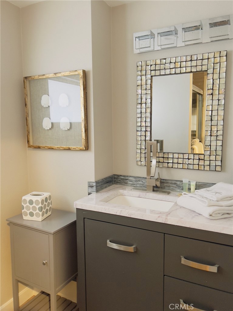 35091 Beach Road Dana Point, CA 92624 - Photo 14 of 27 a bathroom with a granite countertop sink a mirror and a vanity