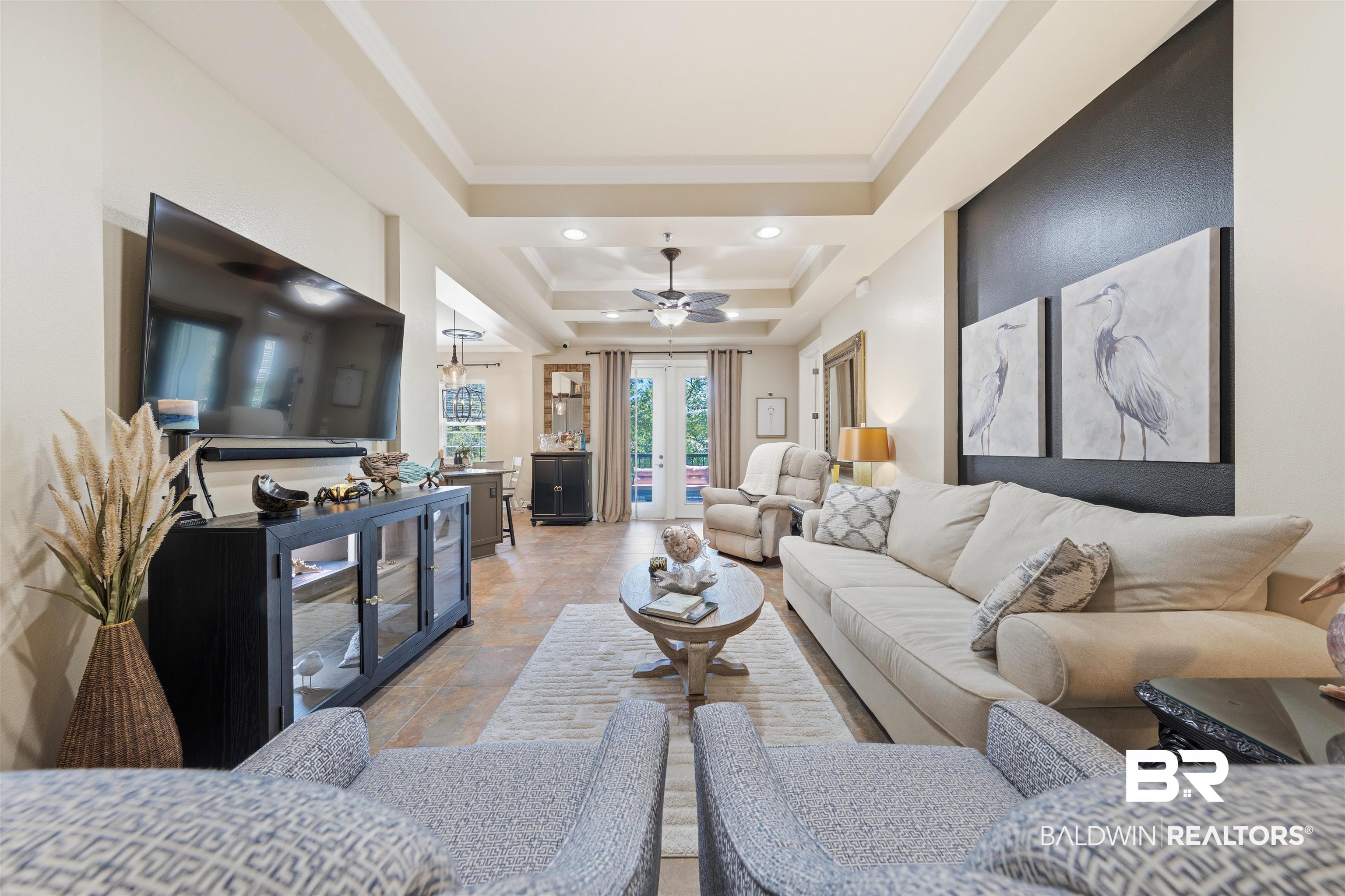 1430 Regency Road, Unit H202 Gulf Shores, AL 36542 - Photo 21 of 25 Living room featuring light stone finish flooring, recessed lighting, crown molding, a ceiling fan, and a tray ceiling