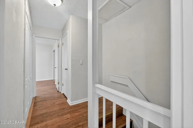 a view of a hallway with wooden floor and entryway