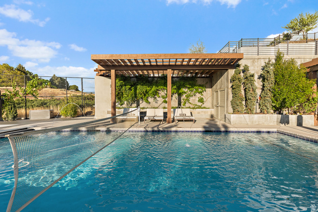 912 North Loafer Canyon Road Elk Ridge, UT 84651 - Photo 59 of 98 Swimming pool with a perimeter of blue mosaic tile, concrete decking, and a wood pergola