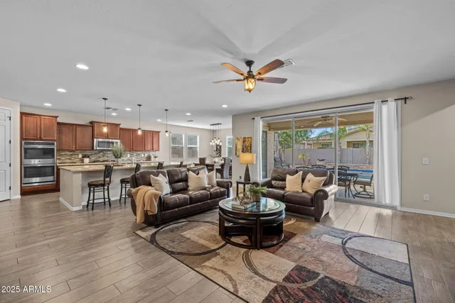 a kitchen with stainless steel appliances granite countertop wooden cabinets a dining table and chairs