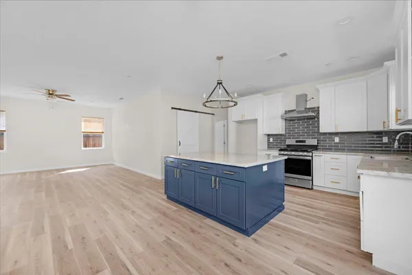 a kitchen with a refrigerator a sink dishwasher stove and oven with wooden floor