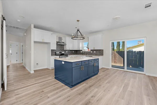 a kitchen with kitchen island granite countertop wooden cabinets and white appliances