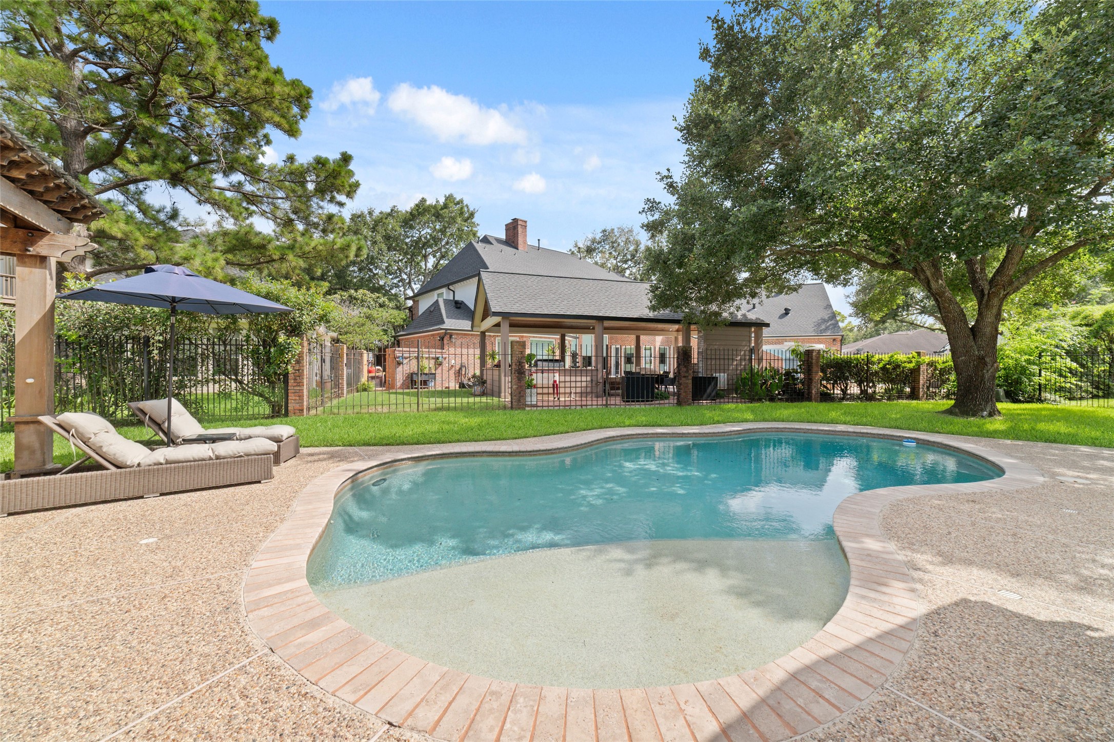 24203 Moon Ridge Court Katy, TX 77494 - Photo 34 of 43 Spacious backyard oasis with a large pool and spa surrounded by beautiful landscape and design. Imagine enjoying this serene and inviting outdoor space!