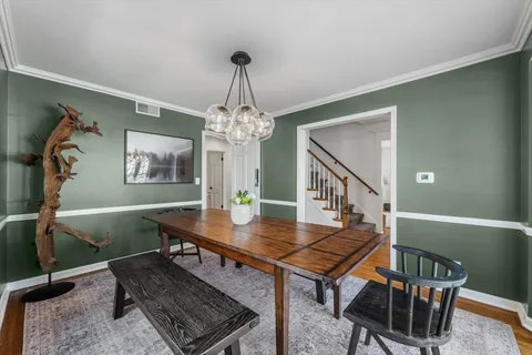 a view of a livingroom with furniture a chandelier and wooden floor